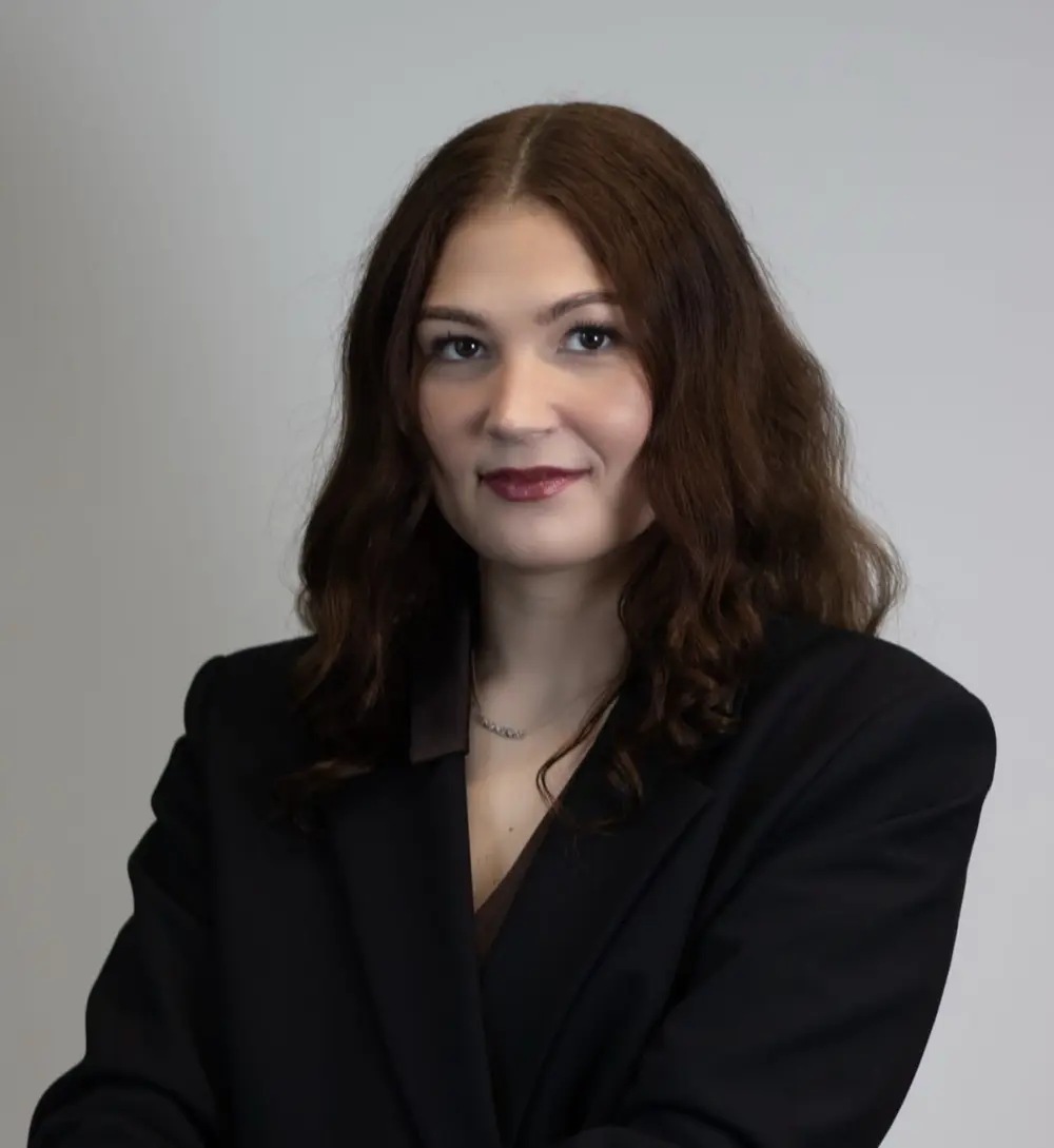 Portrait of Katharina Filin with shoulder-length dark hair, wearing a black blazer